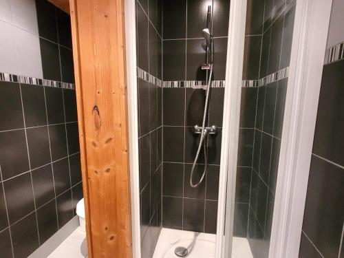 La salle de bains est pourvue d'une douche avec du carrelage noir. dans l'établissement Appartement lumineux 6 pers, balcon, au cœur des Gets, proche pistes et commerces - FR-1-598-76, aux Gets
