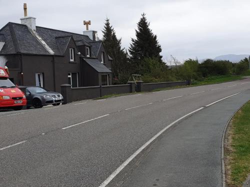 a road with a house and a car parked on the side at BELLFIELD HOUSE in Broadford