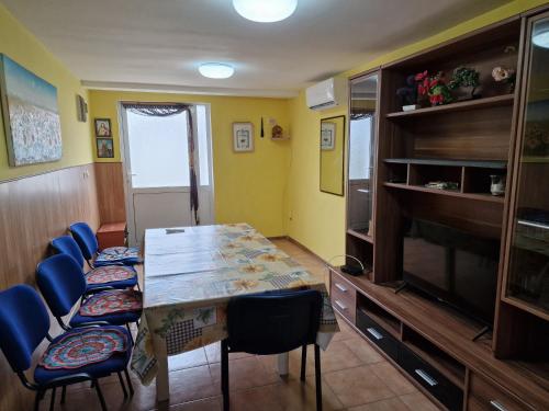 a dining room with a table and blue chairs at Къща за гости Пантови in Gramatikovo