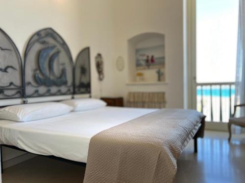 a bedroom with a white bed with a metal headboard at Tramonto in Santa Maria al Bagno