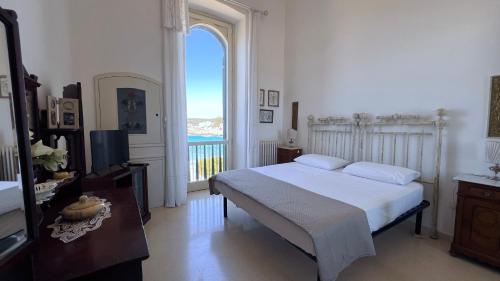 a bedroom with a bed and a large window at Tramonto in Santa Maria al Bagno