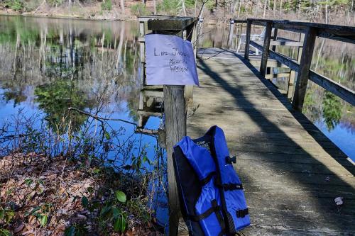 a blue backpack and a sign on a wooden dock at Spacious Catskills Serenity nearby Delaware River Gap w Game Rm Pet Friendly and Fenced Yard in Glen Spey