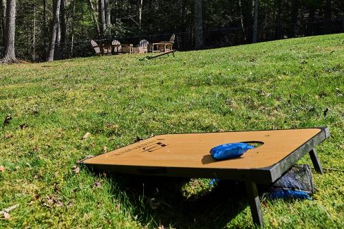 a wooden table in the grass with a blue object on it at Spacious Catskills Serenity nearby Delaware River Gap w Game Rm Pet Friendly and Fenced Yard in Glen Spey