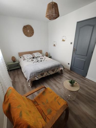 une chambre avec un lit, une chaise et une table dans l'établissement Bretzel et Cigogne, à Ostheim