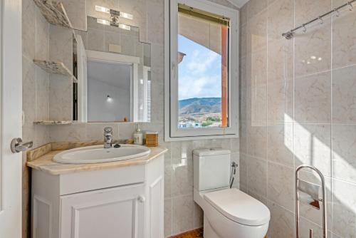 a bathroom with a sink and a toilet and a window at Villa Infinity sea views I Pool I BBQ I Jacuzzi in Almería
