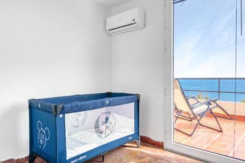 a room with a mirror and a chair and a balcony at Villa Infinity sea views I Pool I BBQ I Jacuzzi in Almería