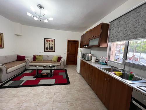 a kitchen and living room with a couch and a table at Lovely spacious house with big garden in Elbasan