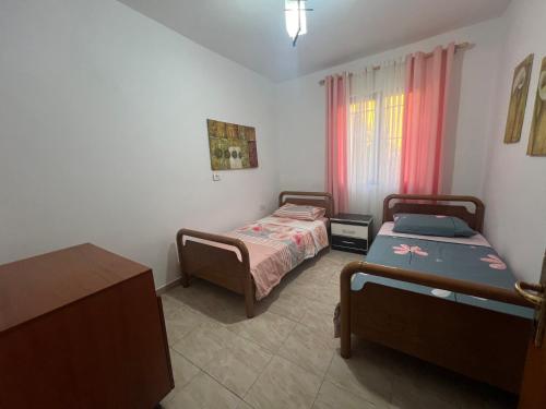 a bedroom with two beds and a window at Lovely spacious house with big garden in Elbasan