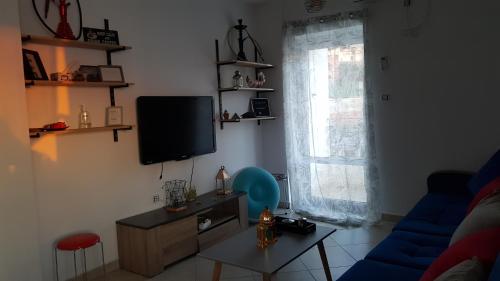a living room with a blue couch and a television at Appartement bord de mer in Mazer
