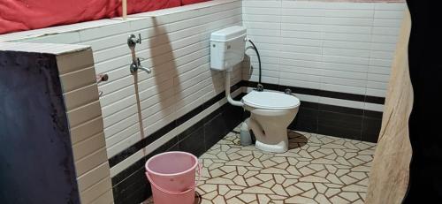 a bathroom with a toilet and a bucket at Gurgaon Paradise Resort Tapovan, Rishikesh in Rishīkesh
