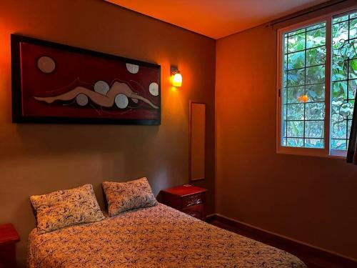 um quarto com uma cama e um quadro na parede em Cabaña/casa Wolf 