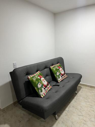 a black couch with two christmas pillows on it at Apartamento Nogales in Bello