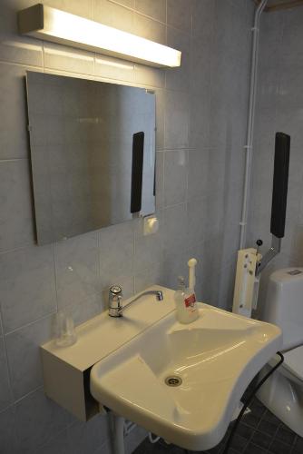 a bathroom with a white sink and a mirror at FolkiaCenter Gästhem - Vieraskoti - Guesthouse in Hanko