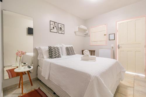 皮雷諾波利斯的住宿－Pousada Lara，白色的卧室配有白色的床和一张桌子