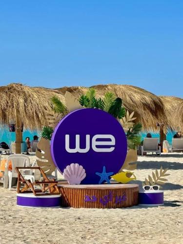a sign on the beach with chairs and umbrellas at Amwaj North coast chalet in 1st floor families only in El Alamein