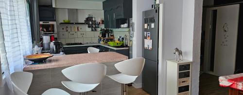 a kitchen with white chairs and a counter top at Vaste maison Fouras 15 pers 6 chbres meublé 3* in Fouras
