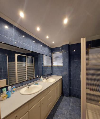 a bathroom with two sinks and a shower at Cozy room in Denia