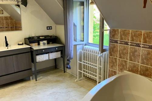 une salle de bain avec une baignoire et un lavabo dans l'établissement un balcon sur la Dordogne, à Berbiguières