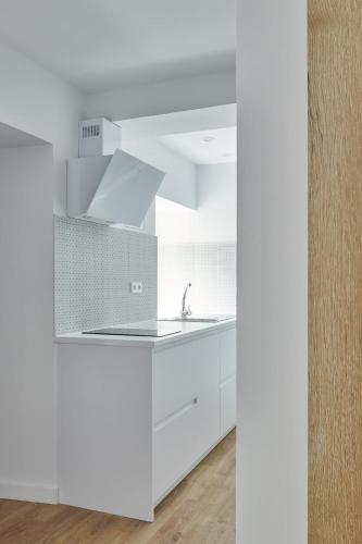 a kitchen with white cabinets and a sink at La casita de Ane - Panticosa in Panticosa