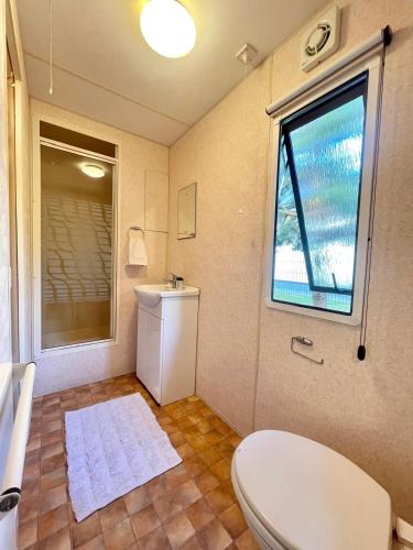a bathroom with a toilet and a window at Domek holenderski in Rydzewo