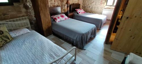 a room with two beds and a mirror at Algarabiastaying 3 granja San Julián in Medina de Pomar