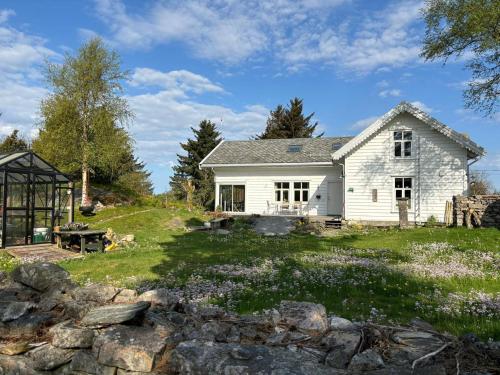 Casa blanca con pared de piedra en Koselig stort gårdshus, m/boblebad. Båt kan leies, en Forland