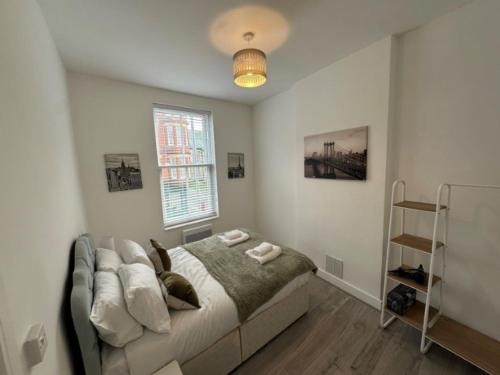 a bedroom with a bed with a couch and a window at Central Colwyn Bay Studio Flat 2A in Colwyn Bay