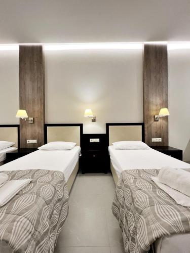 pokój hotelowy z 2 łóżkami i 2 lampami w obiekcie Leni w Paralii Katerinis