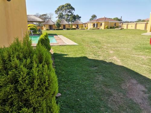 a yard with a house and a swimming pool at Lunganakho Country Lodge in Port Edward