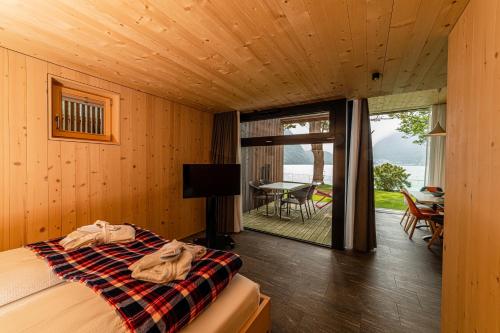 a bedroom with a bed and a balcony with a table at Hotel Le Prese in Poschiavo