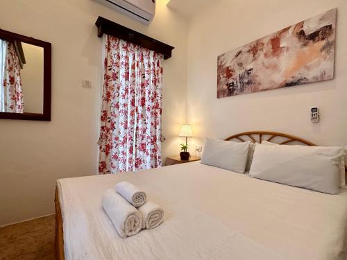 a bedroom with a white bed with towels on it at Nestwood - By The Beach Goa in Benaulim