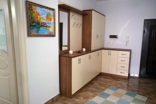 um quarto com paredes brancas e uma pintura na parede em Meti Apartment em Durrës