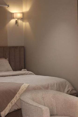 a bedroom with two beds and a light on the wall at غرفه وصاله وسطح خاص vip in Al Hofuf
