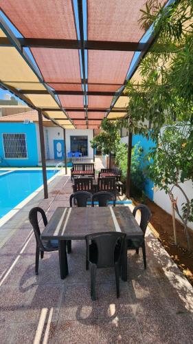 um pátio com uma mesa e cadeiras e uma piscina em Julie Home Chalet em Madaba