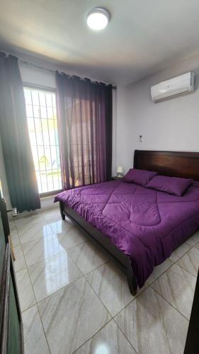 uma grande cama roxa num quarto com janelas em Julie Home Chalet em Madaba
