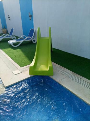 uma piscina com um objecto verde ao lado de uma piscina em Julie Home Chalet em Madaba