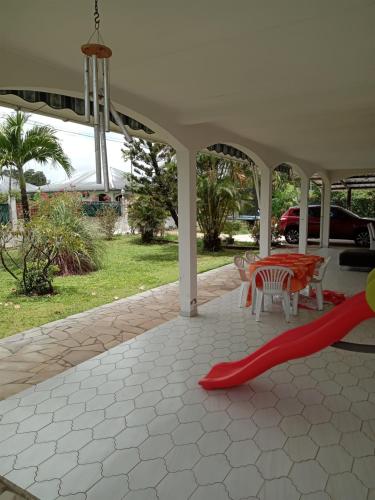 a patio with a red slide and a table and chairs at chambre rémire morne coco in Rémire-Camp