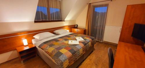 a bedroom with a bed with two towels on it at Penzión Biela Voda in Veľká Lomnica