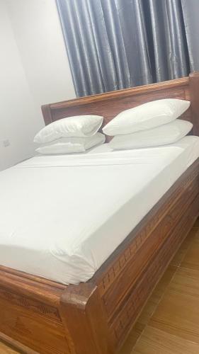 a bed with white sheets and pillows on it at PM Lodge and Restaurant in Matemwe