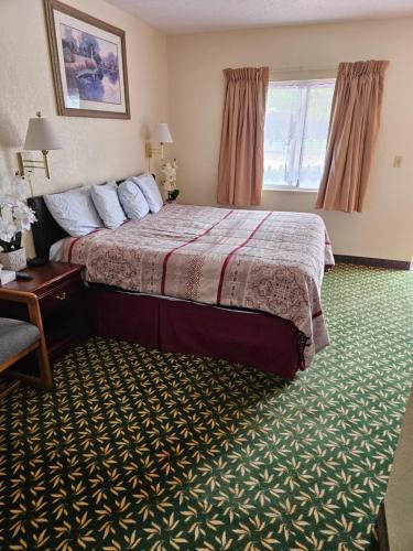 a hotel room with a bed and a window at Travel Inn in Canon City