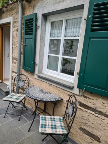 two chairs and a table in front of a building at FeWo Alt Beilstein in Beilstein