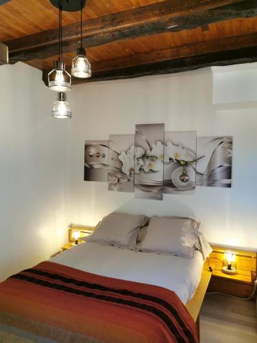 - une chambre avec un lit et des photos sur le mur dans l'établissement Aux gites de Joséphine, à Blars