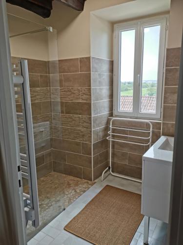une salle de bain avec une douche et un lavabo et une fenêtre dans l'établissement Aux gites de Joséphine, à Blars
