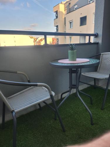 a small table and two chairs on a balcony at Apartman NS PRIVATE PARKING in Novi Sad