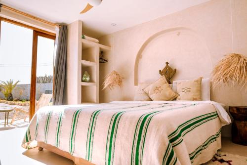 a bedroom with a large bed with a large window at Villa Madame Babouche, chambre Fériel, SdB privative in Oulad el Madani
