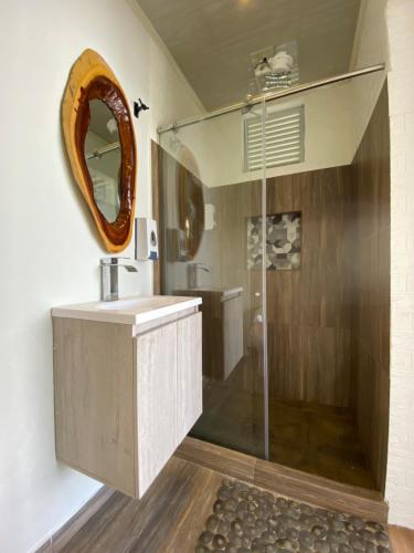 La salle de bains est pourvue d'une douche, d'un lavabo et d'un miroir. dans l'établissement Chalet de Descanso y Tranquilidad, à Manizales