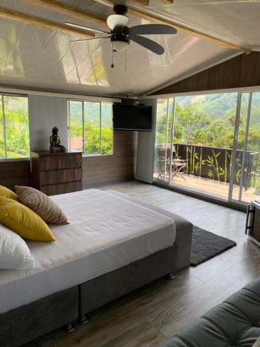 sypialnia z dużym łóżkiem i wentylatorem sufitowym w obiekcie Chalet de Descanso y Tranquilidad w mieście Manizales