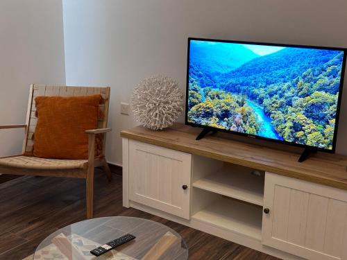 a living room with a flat screen tv on a table at The Beach House in Birżebbuġa
