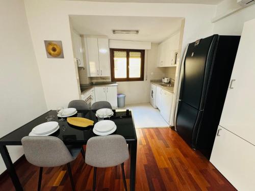 una cucina con tavolo da pranzo e frigorifero nero di EL TEMPLE a Saragozza