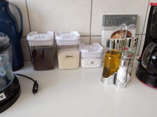a kitchen counter with some containers on a counter top at Espaço Acolhedor perto da Praia. in São Vicente